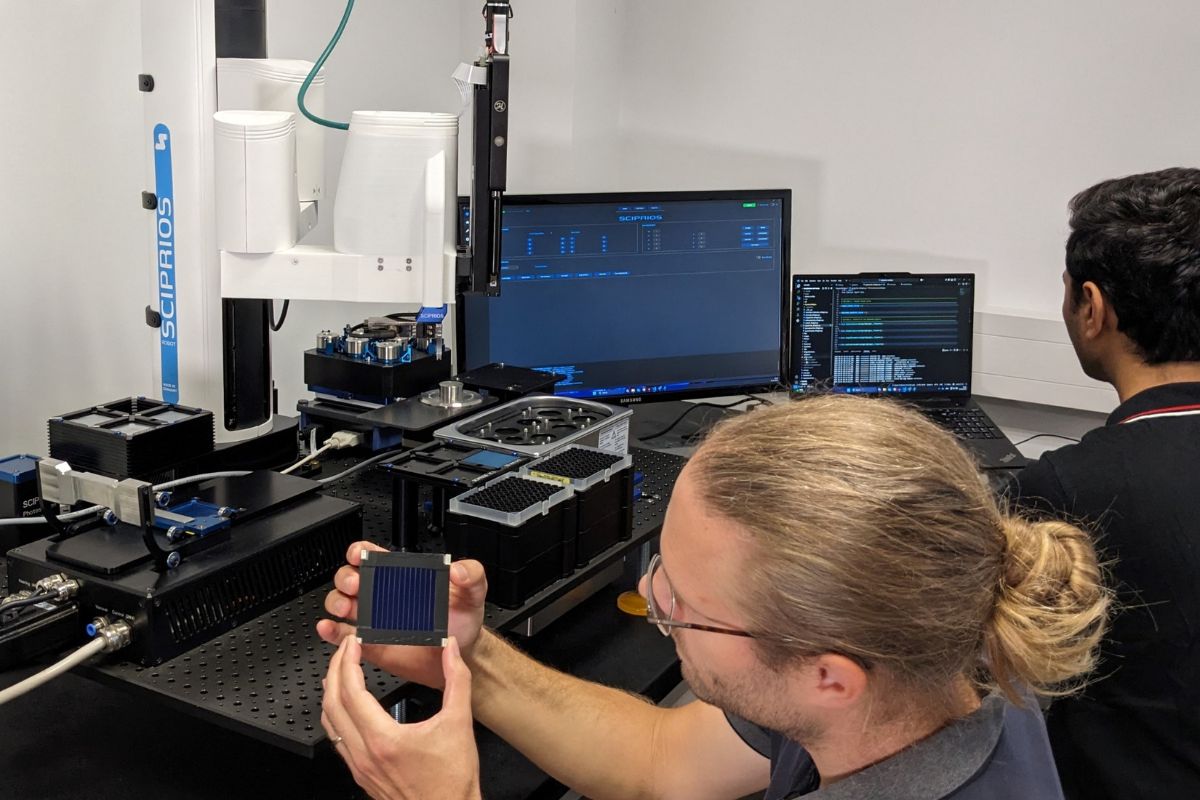 Ein Mitarbeiter zeigt ein organisches Solarmodul im Labormaßstab